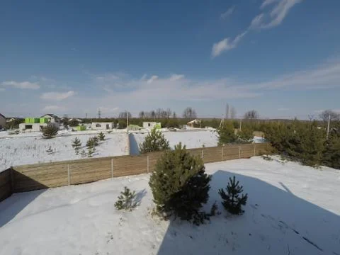 Plot of land in winter. Construction of a private house. Fence on the land in wi Photos