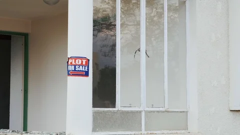 Plot for sale sign sticker on house building. House for sale on lawn white house Vídeos de archivo 113759142