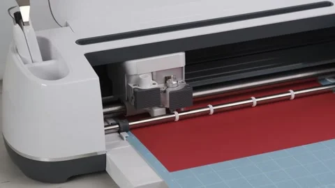 Plotter, digital flatbed cut out details on dark red cardboard on blue mat. Stock Footage 277937119
