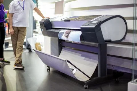 Plotter prints a poster. standing next to people in blur. close-up, background Stock Photos