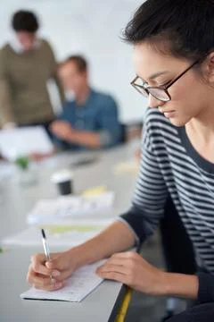 Plotting her success. an attractive young woman working in an office with 스톡 사진