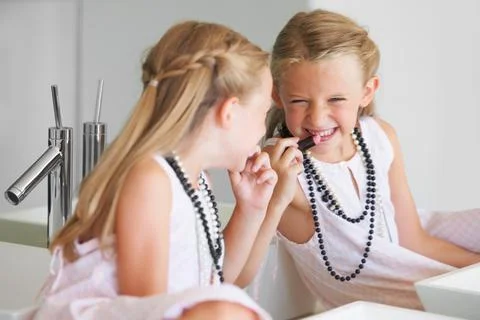 Plotting something mischievious. Naughty little girl in front of a mirror with Fotos de archivo