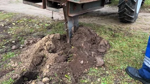 Plow digging trench with cable in soil, agricultural machine laying groundwork Stock Footage 337065552
