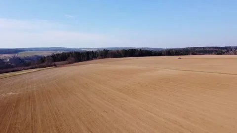 Plowed fields next to the forest and wind turbines Stock Footage 172378902