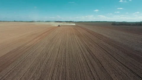 Plowed land as a background. Two red tractors on the field. 스톡 동영상 128276391