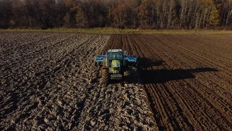 Plowing a field in autumn, front view of a tractor with a plow in work Video stock 197058202