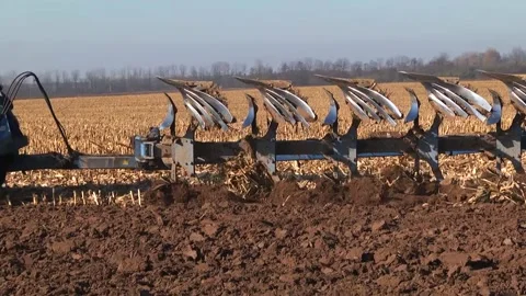 Plowing in the field by a tractor with a trailed unit Stock Footage 145943629