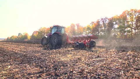 Plowing in the field by a tractor with a trailed unit Stock Footage 145943630
