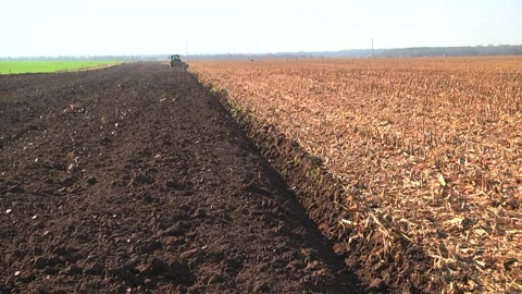 Plowing in the field by a tractor with a trailed unit Stock Footage 145943633