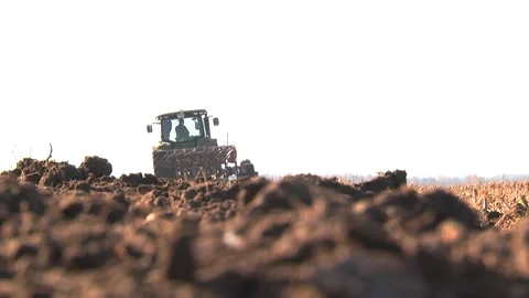 Plowing in the field by a tractor with a trailed unit Stock Footage 145943635