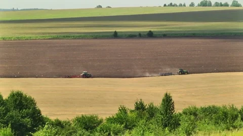 Plowing in the field by a tractor with a trailed unit Stock Footage 145943646