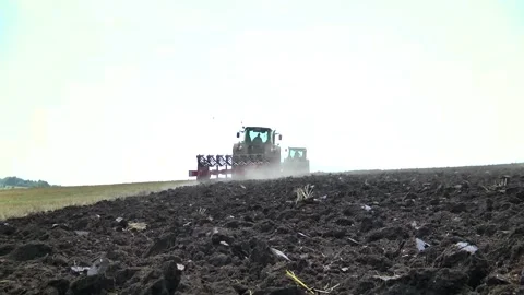 Plowing in the field by a tractor with a trailed unit Stock Footage 145943650
