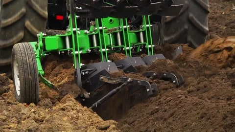 Plowing in the field by a tractor with a trailed unit Stock Footage 145943660