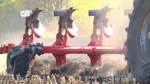 Plowing in the field by a tractor with a trailed unit Stock Footage 145943687