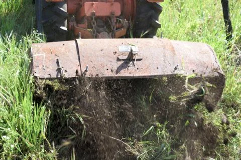 Plowing of the soil with old rotary hoe Stock Photos