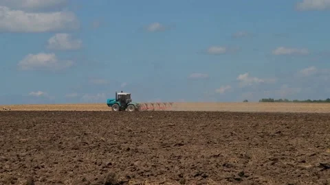 Plowing with a tractor with a plow in the field Stock Footage 166947061