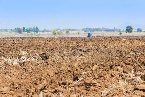 Plowing tractor working in field. Stock Photos
