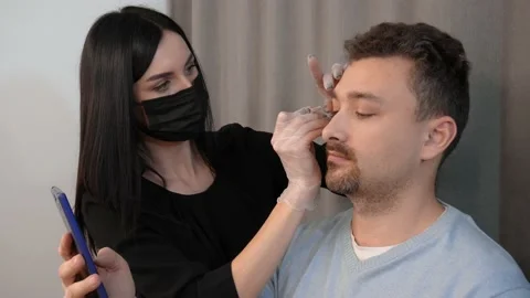 Plucking male eyebrows Stock Footage 148734941