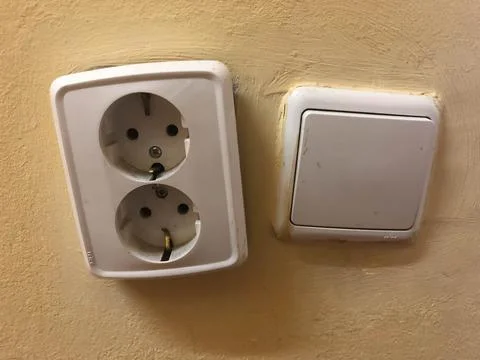 A plug and a switch next to each other close up old ones. Stock Photos