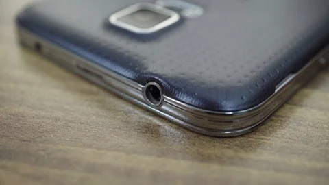 Plug audio connector into smartphone, close-up Stock Footage 96071052