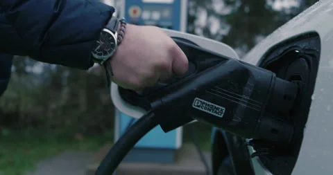 Plug In Connector Into Socket of Electric Vehicle at Charging Station, Stock Footage 231268572