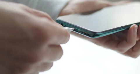 The plug connects to charge the mobile phone battery. Close-up of a smartphone Video stock 165920109