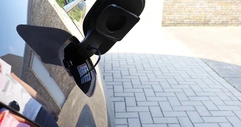 Plug in electric car to charge Stock Footage 129430228