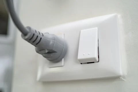 Plug electric in the socket on wall at house Stock Photos