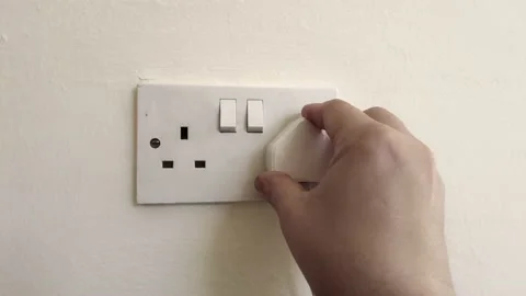 Plug in electrical appliance and switch on, UK British socket Stock Footage 208621345