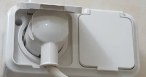 Plug is insert into socket. Turning on the electrical appliance Stock Footage 315800113