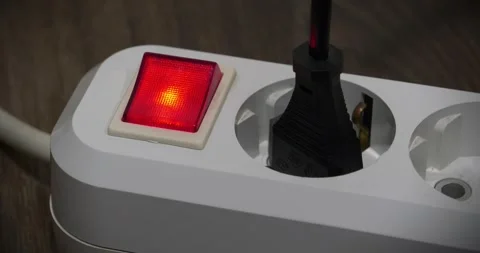 Plug is inserted into white electric portable socket with red power indicator Stock Footage 315439389