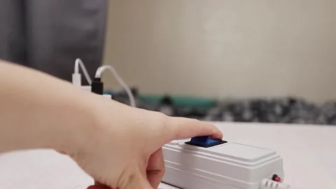 Plug on, power connect, the hand presses the button on the extension socket.. 스톡 동영상 247717463