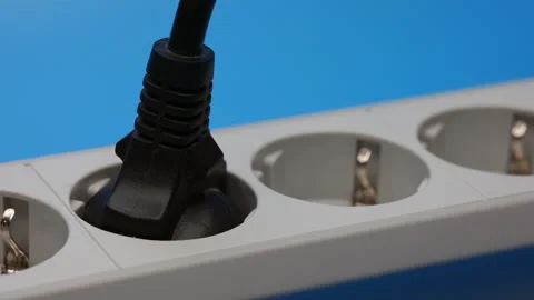 Plug In The Socket Of An Electric Extension Cord On Blue Background. Panning Dol Stock Footage 241173392