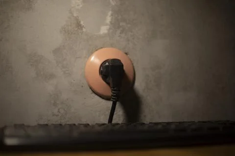 Plug in socket. Electricity at home. Black cable. Stock Photos