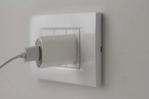 Plug with USB cable from device is plugged into light socket Stock Photos