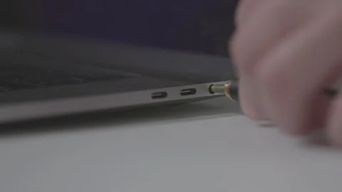 Plugging in a 1/8 headphone jack into a computer laptop Stock Footage 89800660