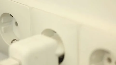 Plugging a black power plug in a white wall socket 库存影片 143034252