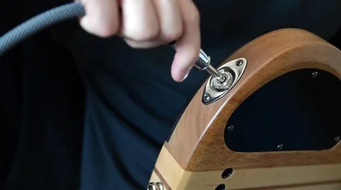 Plugging a Cable Into a Guitar Wide Stock Footage 50710131