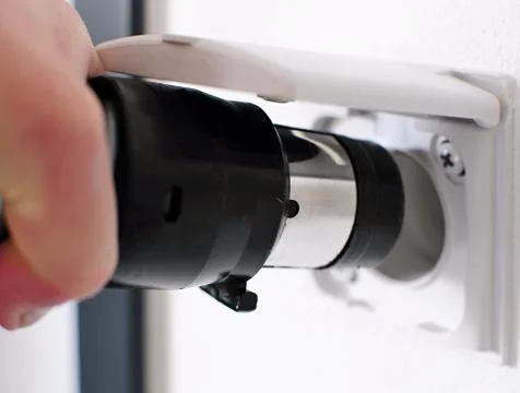 Plugging central vacuum cleaner in to wall inlet Stockfoto's