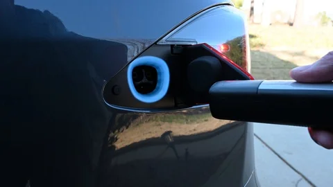 Plugging in a charge cable to an electric car. Stock Footage 121002024