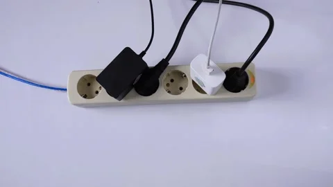 Plugging the charger into electric socket on white table Stock Footage 275872369