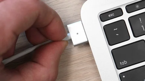 Plugging The Charging Cable Into a Laptop Computer Top View of The Desk Stock Footage 90055139