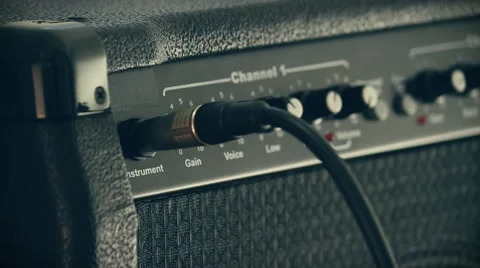 Plugging cord to guitar amplifier Stockbeeldmateriaal 67679615
