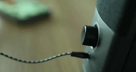 Plugging earphones jack cable into speaker to listen to music on smart Stock-Footage 115060944