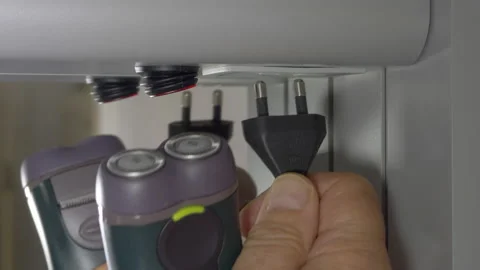 Plugging electric shaver into socket of bathroom cabinet, then switching on. Video stock 138236273