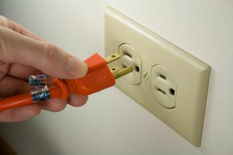 Plugging Electrical Cord into Outlet Foto stock