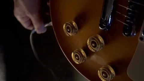 Plugging a jack into electric guitar Stock Footage 93998375