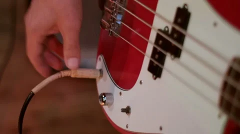 Plugging a jack lead from amp into a bass guitar in a music recording studio Vídeo Stock 62966311