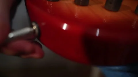 Plugging a jack lead from amp into a bass guitar in a music recording studio Видео 66679820