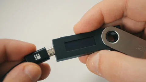 Plugging in Ledger Nano hardware Bitcoin cryptocurrency wallet entering PIN code Stock Footage 100465455